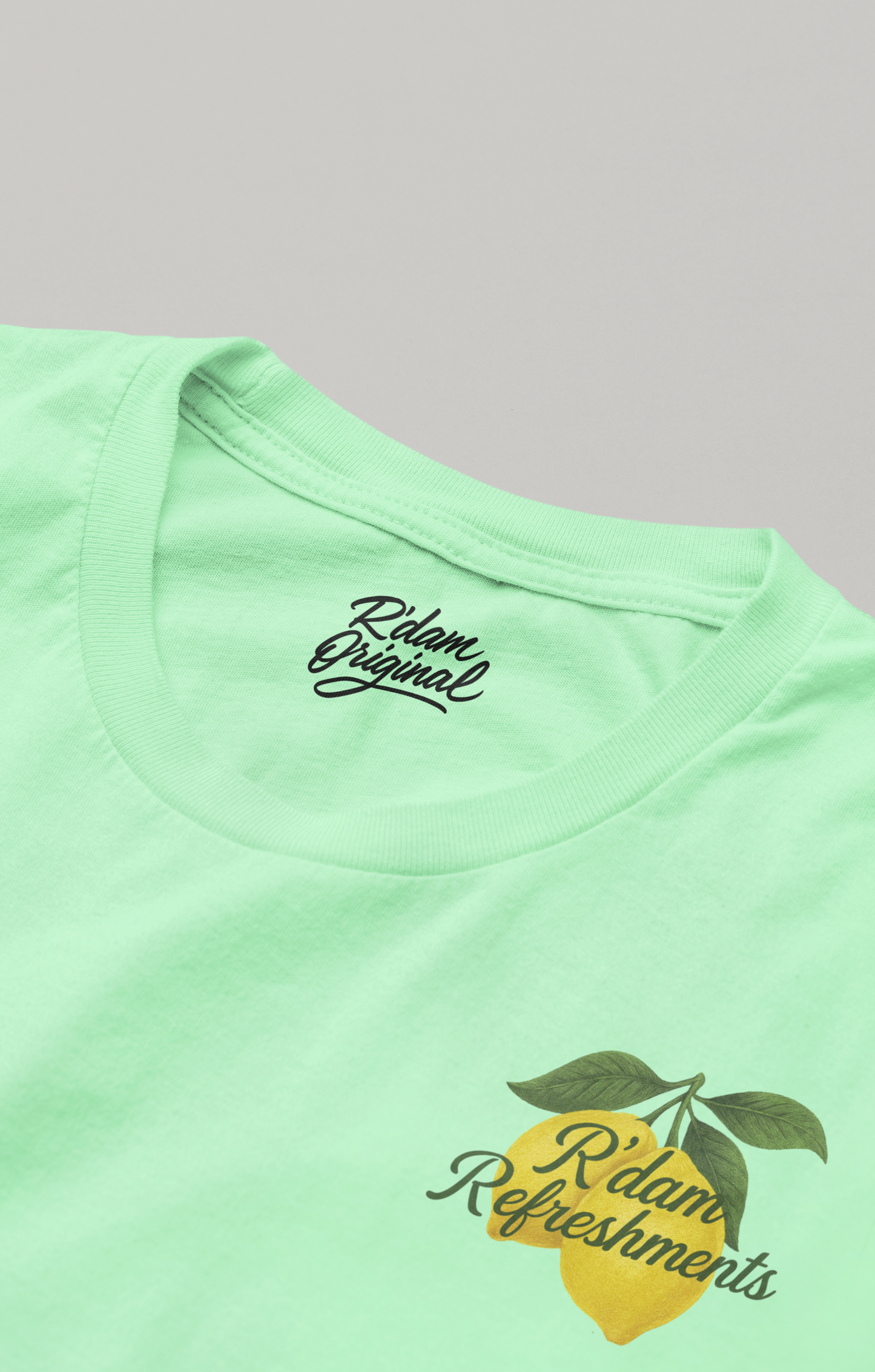 Mintgroen T-shirt met citroenprint en “R’dam Refreshments” tekst – borstzijde