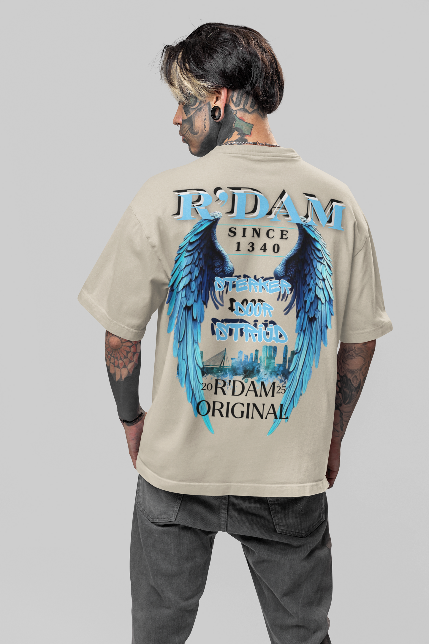 Sterker door Strijd" oversized heren T-shirt van R’dam Original. Heavyweight katoen, urban streetwear met blauwe engelenvleugels en Rotterdam skyline.