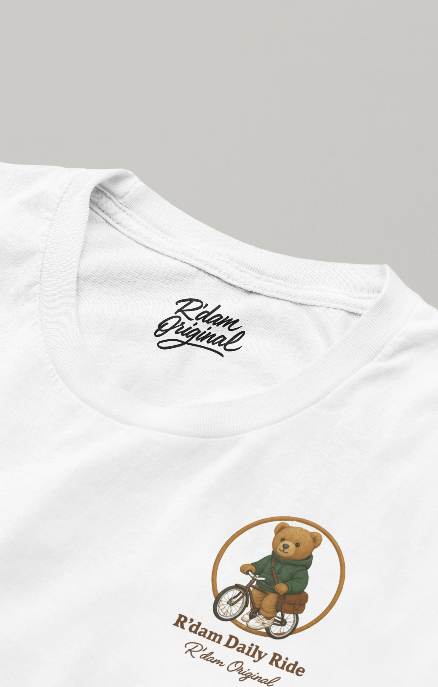 Witte T-shirt met fietsende teddybeer, close-up borstprint en label