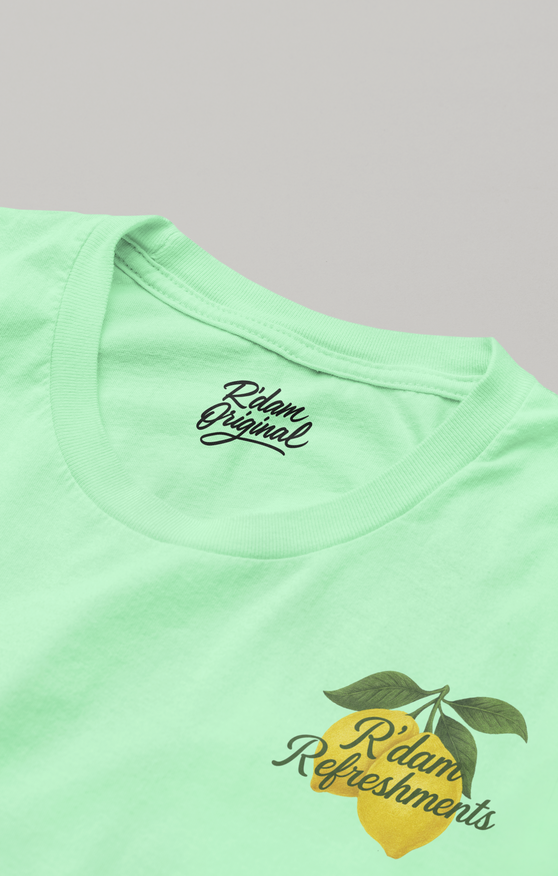 Mintgroen T-shirt met citroenprint en “R’dam Refreshments” tekst – borstzijde