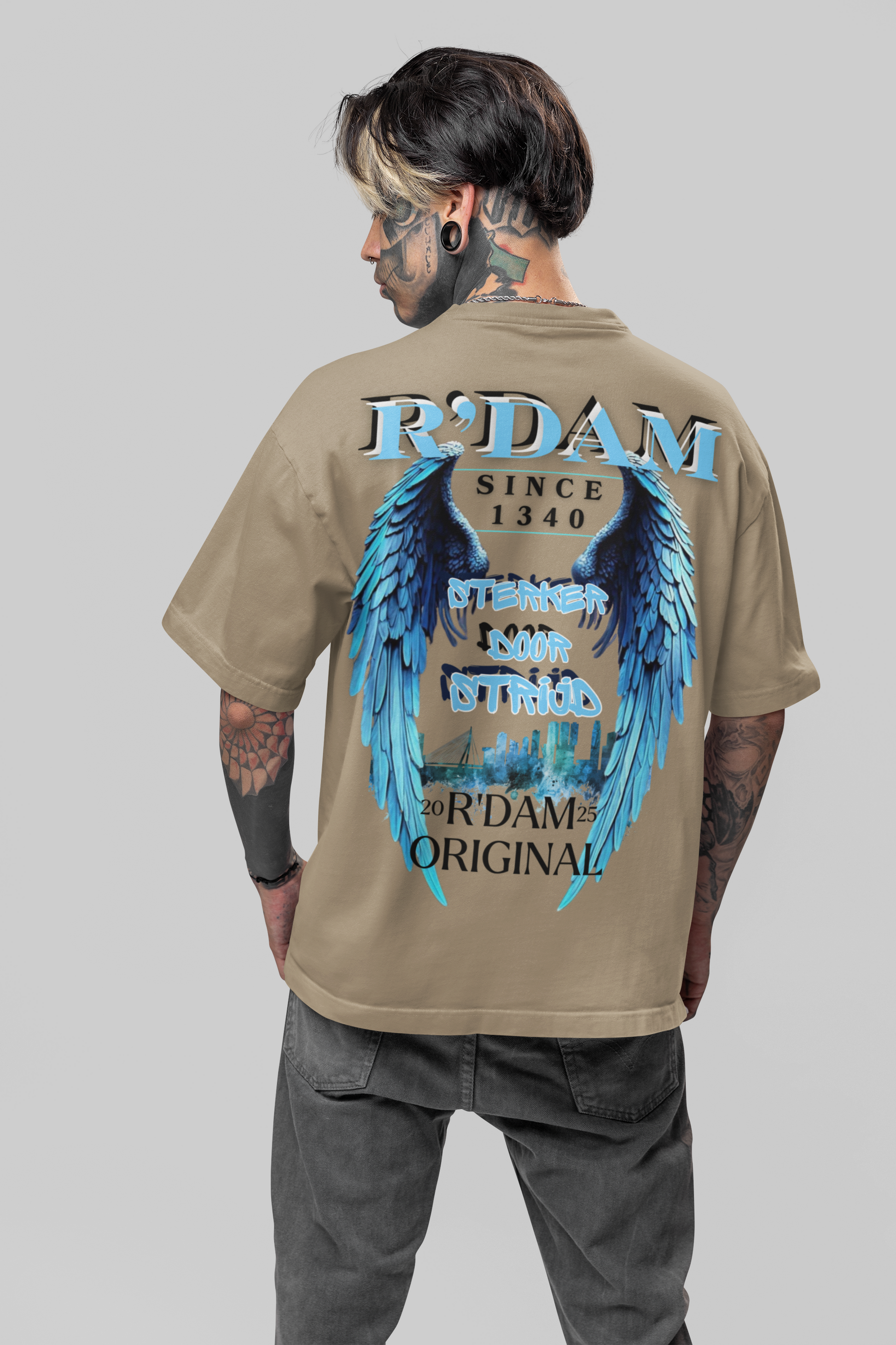 Sterker door Strijd" oversized heren T-shirt van R’dam Original. Heavyweight katoen, urban streetwear met blauwe engelenvleugels en Rotterdam skyline.